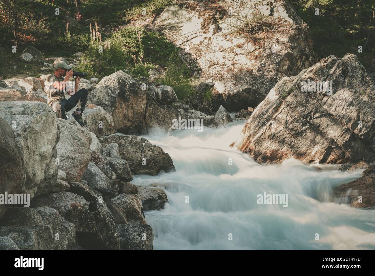 Professioneller Landschaftsfotograf in den 40er Jahren, der Bilder vom malerischen alpinen Wasserfall fotografiert. Branchenthema Reise- und Landschaftsfotografie. Stockfoto