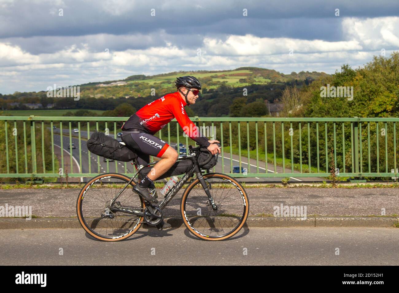 Männlicher Radfahrer Reiten Kuota Sport Carbon Rennrad auf dem Land Route  überqueren Autobahnbrücke im ländlichen Lancashire, Großbritannien  Stockfotografie - Alamy