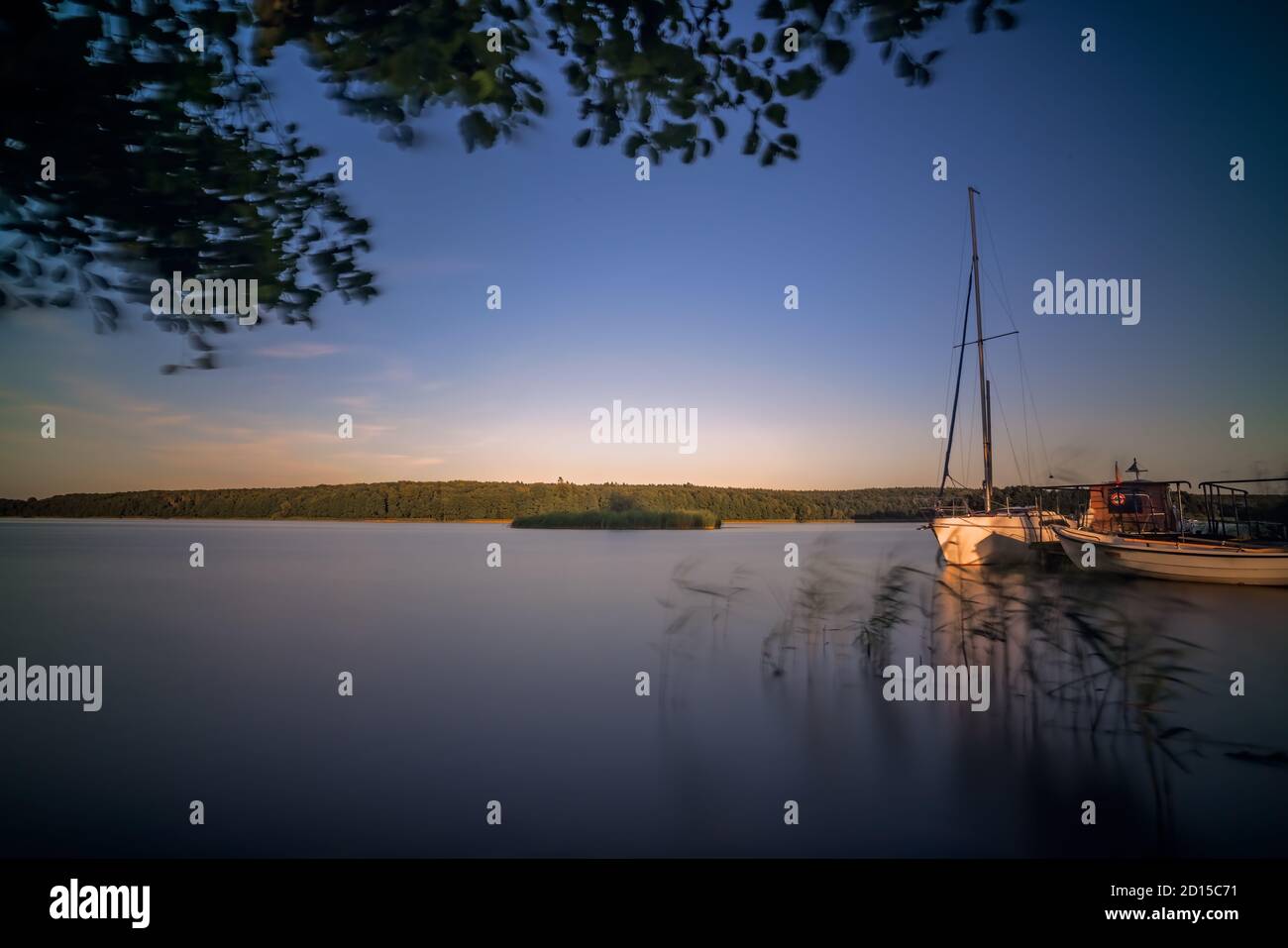 Segelboote und eine kleine Anlegestelle am Ufer der großen Jezioro Ostrowieckie in Pojezierze Zninskie im Sommer, Polen Stockfoto