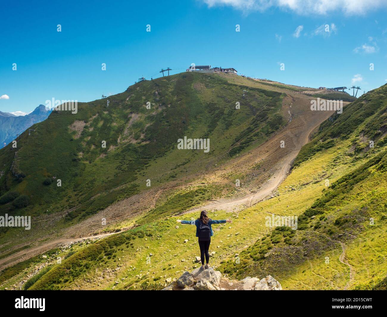 Mensch auf dem Hintergrund der Natur, Einheit mit der Natur. Junge Touristin auf dem Hintergrund von Felsen, Arme ausgestreckt. Stockfoto