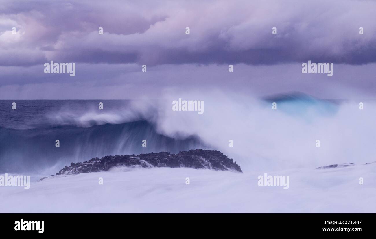 Große Welle bricht über felsige Küste. Stockfoto