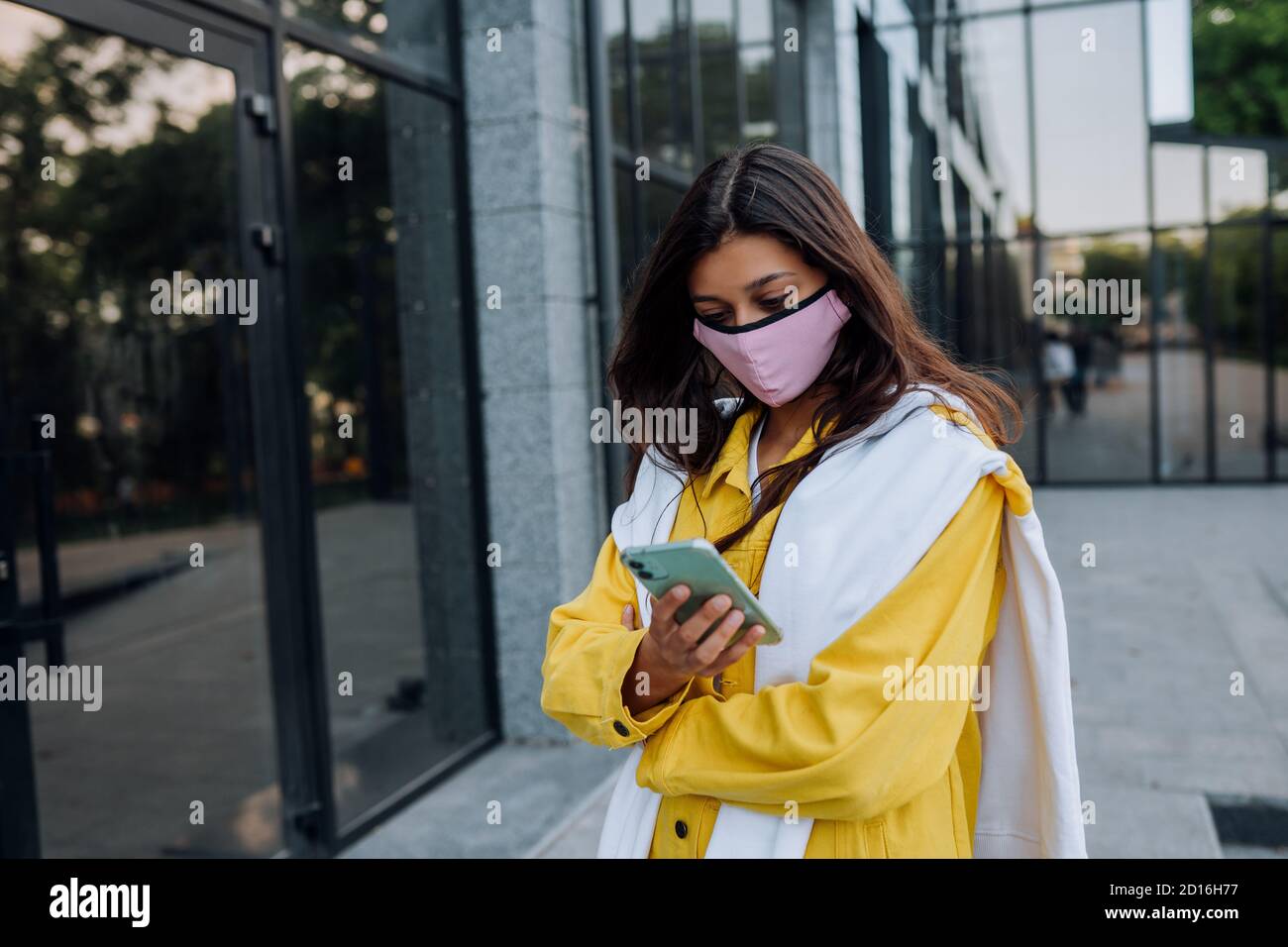 Junge Frau trägt Maske posiert auf der Straße. Stockfoto