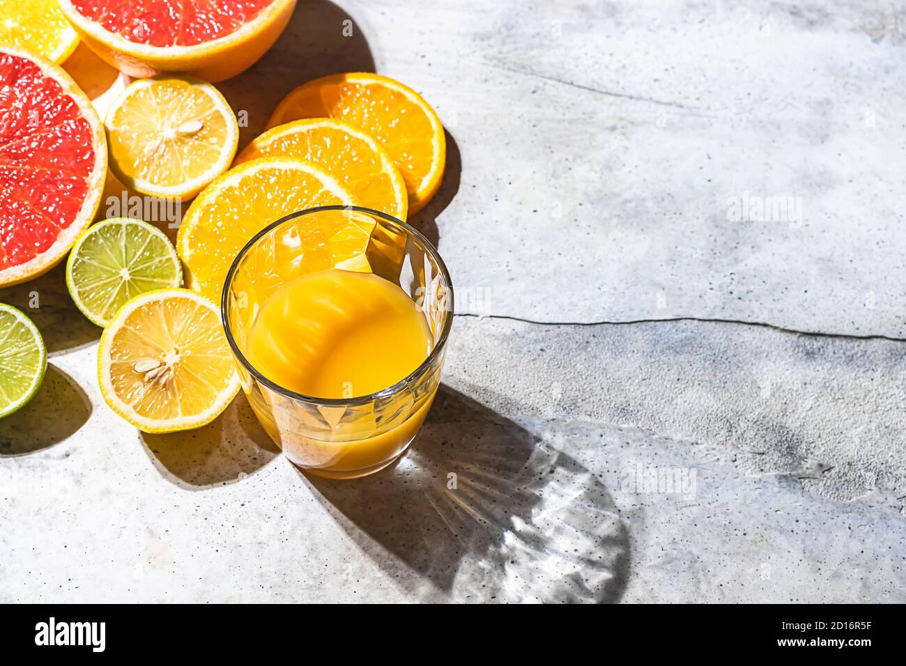 Zitrussaft und frische Früchte, Limette, Grapefruit, Orange, Zitrone im Sonnenlicht. Entgiftungsgetränk. Stockfoto