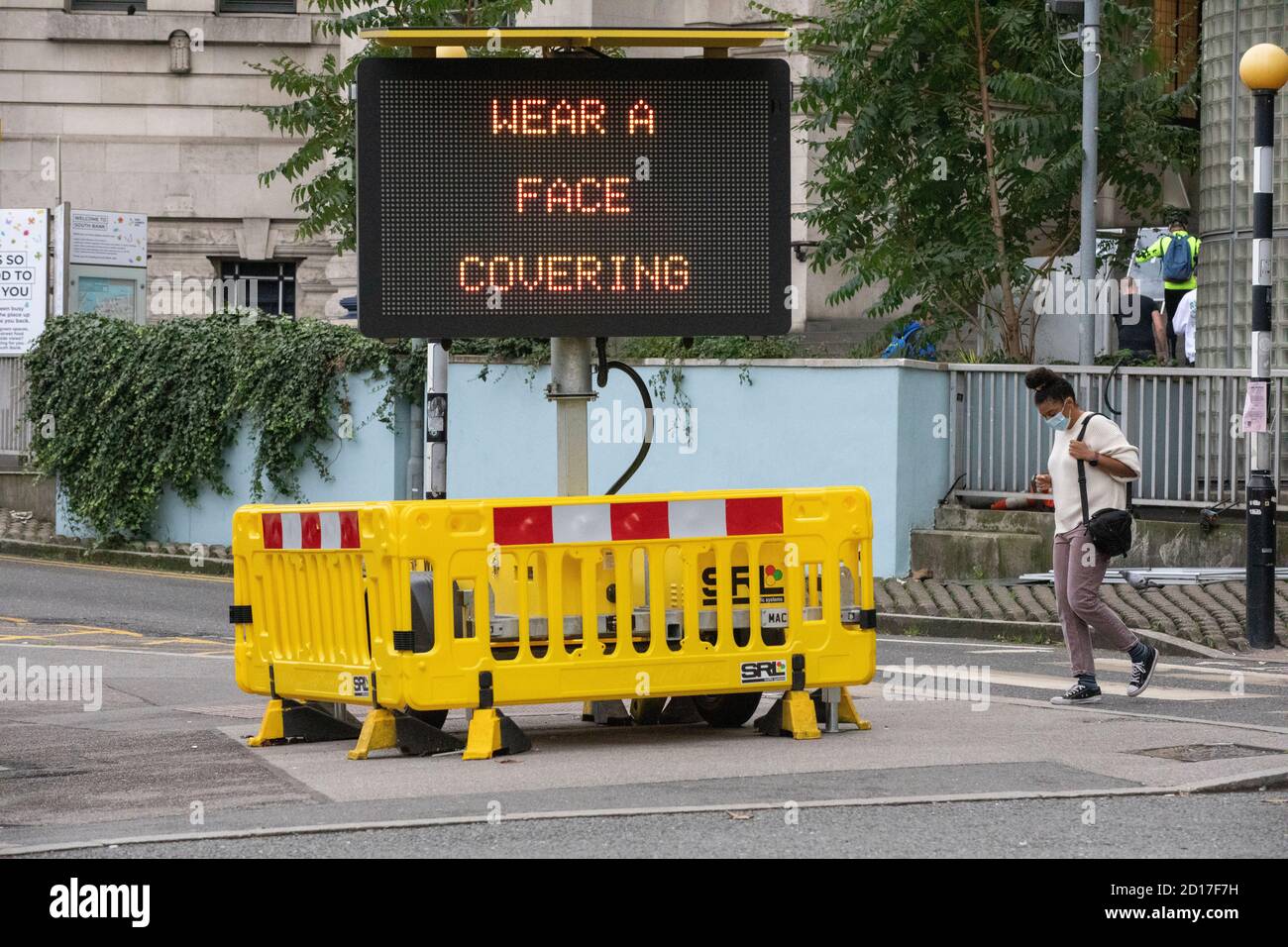 "Tragen SIE EINE Gesichtsbedeckung" Advisory-Schild weist Pendler, eine Gesichtsmaske auf öffentlichen Verkehrsmitteln tragen, Waterloo Station, London, England, Vereinigtes Königreich Stockfoto