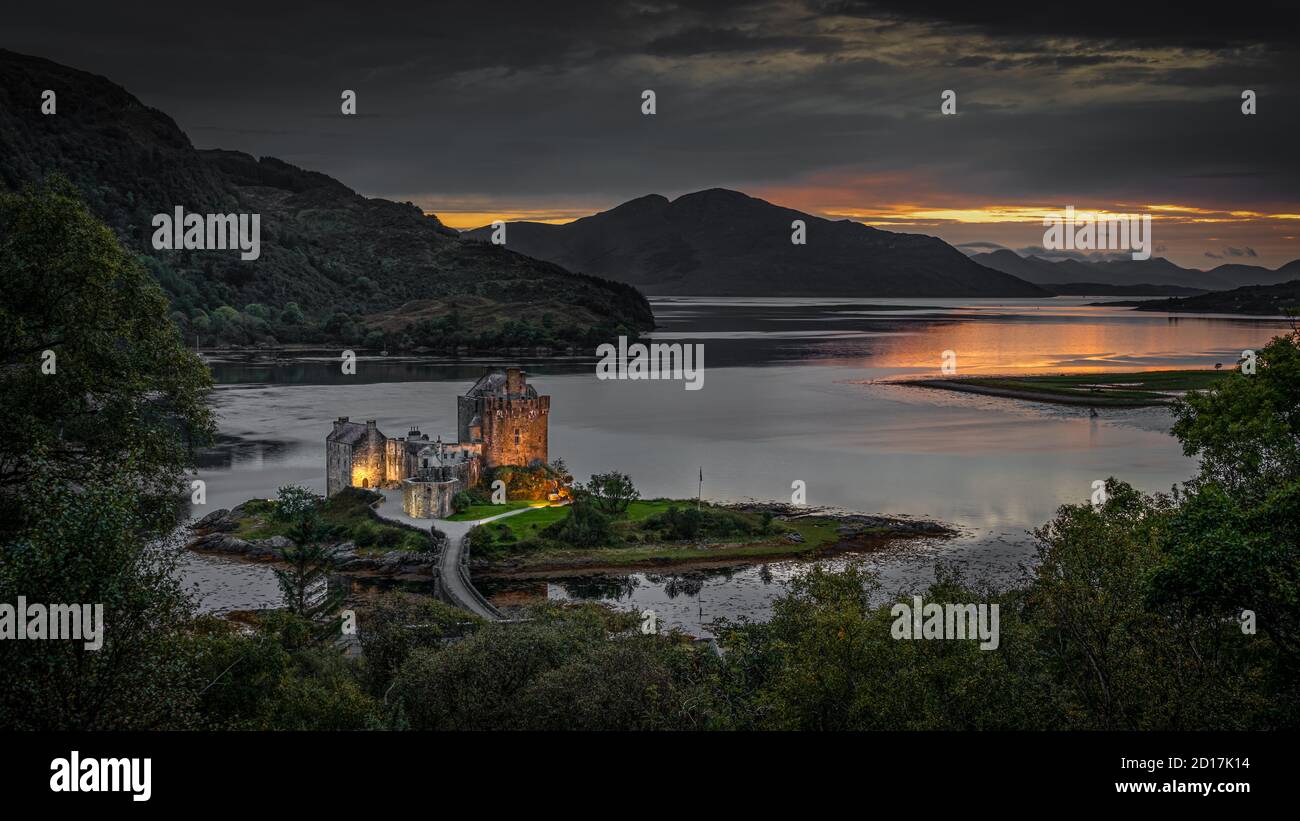 Aufgenommen bei Sonnenuntergang, ein Foto von Eilean Donan Castle im schottischen Hochland. Die Burg ist im Licht der Lichter erleuchtet Stockfoto