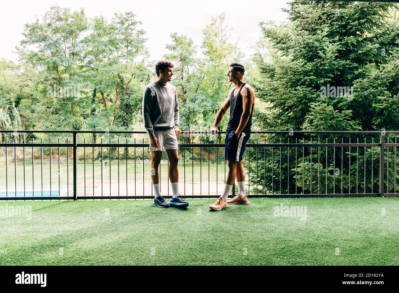 Zwei Männer in Sportkleidung sprechen nach dem Training im Fitnessraum Stockfoto