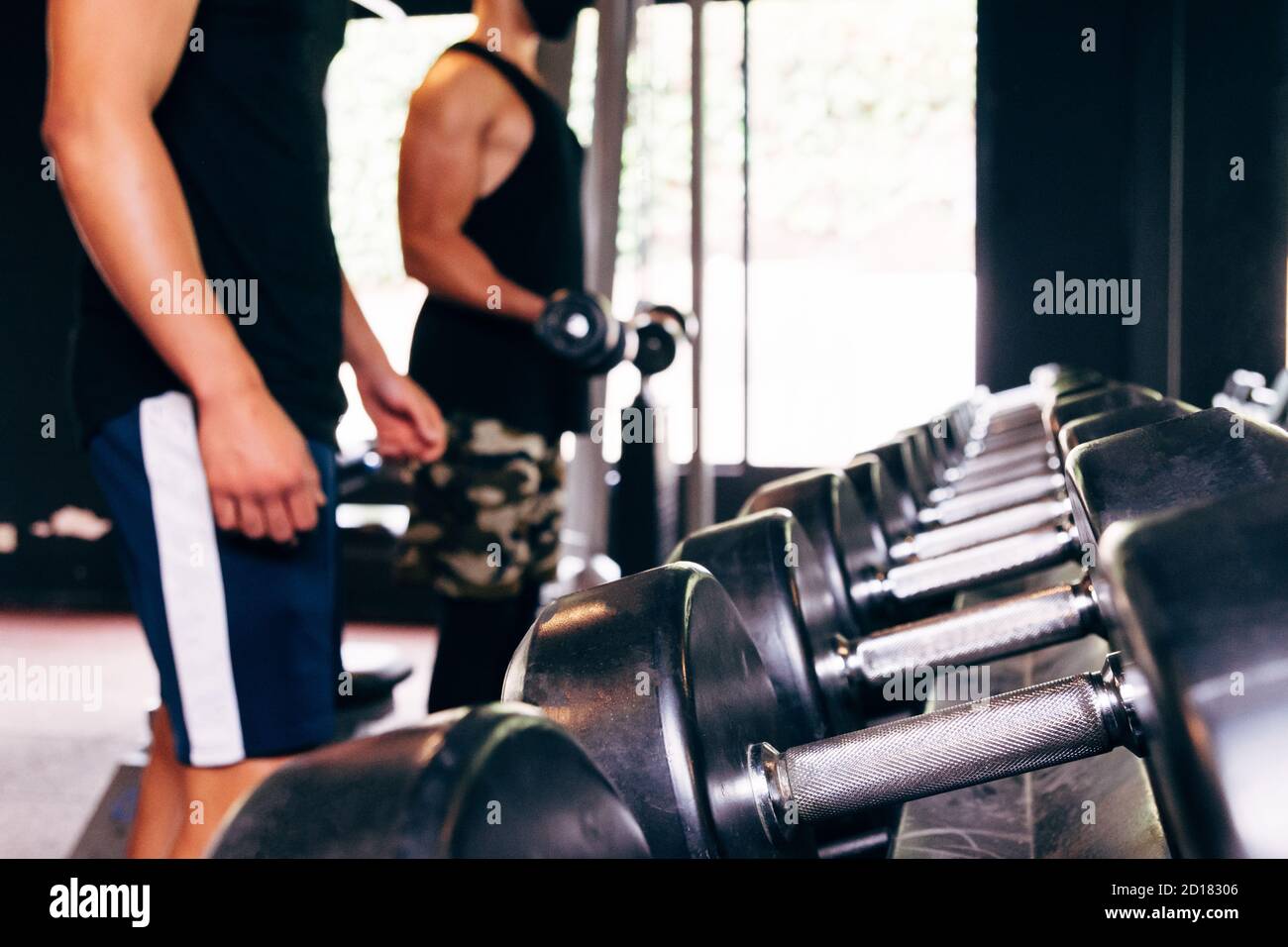 Stehen Sie mit Hanteln. Sport und Fitness-Raum. Krafttrainingsgeräte Stockfoto