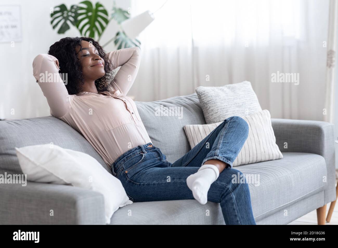 Wochenende Zu Hause. Entspannte Afroamerikanische Frau Schiefen Zurück Auf Couch Stockfoto