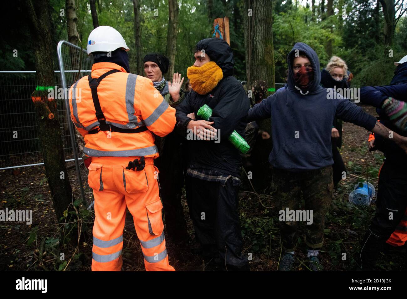 Cubbbington Woods, Warwickshire, Großbritannien. Oktober 2020. In den frühen Morgenstunden des 5. Okt. 2020 ergreifen friedliche HS2-Demonstranten Maßnahmen zum Schutz der Eichen und alten Wälder, die für die Zerstörung in Cubbbington Woods, Warwickshire, Großbritannien, markiert sind. Demonstranten erhalten Zugang zu dem Land, das HS2 erworben hat und Arme um Bäume verbindet, die mit Farbe gekennzeichnet sind Kredit: Denise Laura Baker/Alamy Live News Stockfoto