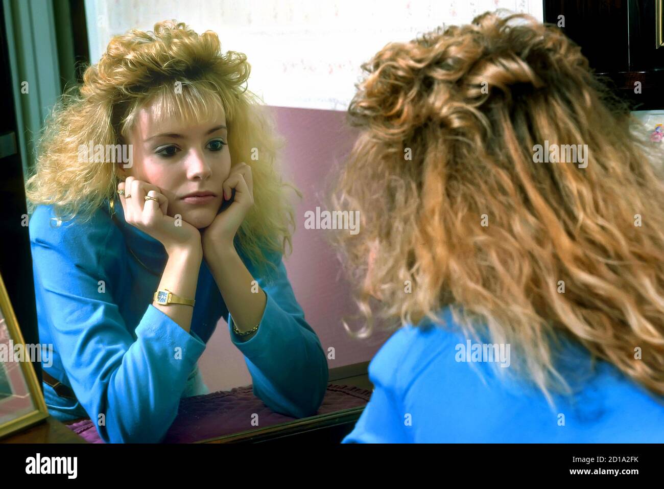Teen Frau schaut sich im Spiegel Stockfoto