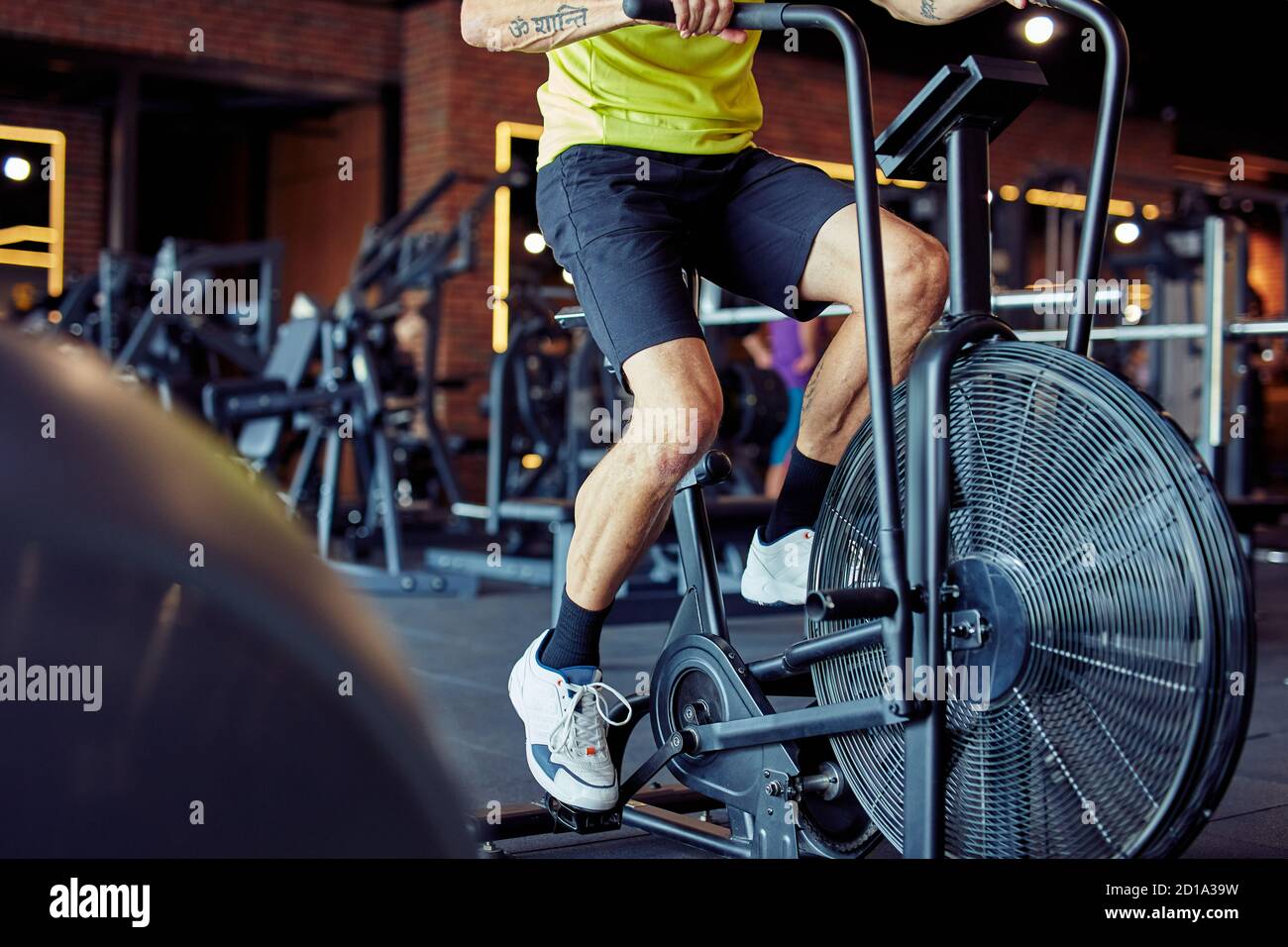 Kurzer Schuss von athletischen Mann in Sportbekleidung tun Radfahren auf Ergometer im Fitnessstudio, Cardio-Training Stockfoto