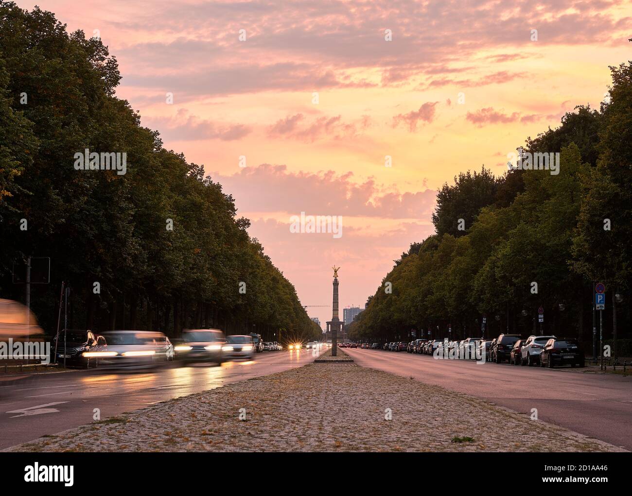 Straße durch den Tiergarten Park mit Bewegung verschwommen Autos und Berlins Siegessäule im Hintergrund bei Sonnenuntergang Berlin Stockfoto