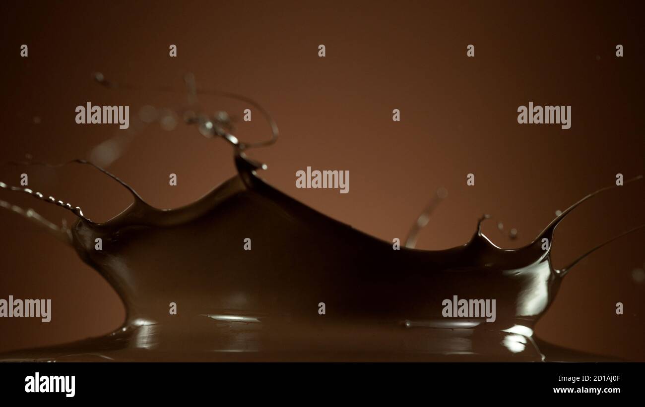 Abstrakte Form von spritzendem heißer Schokolade isoliert auf weichem Gradienten Hintergrund Stockfoto