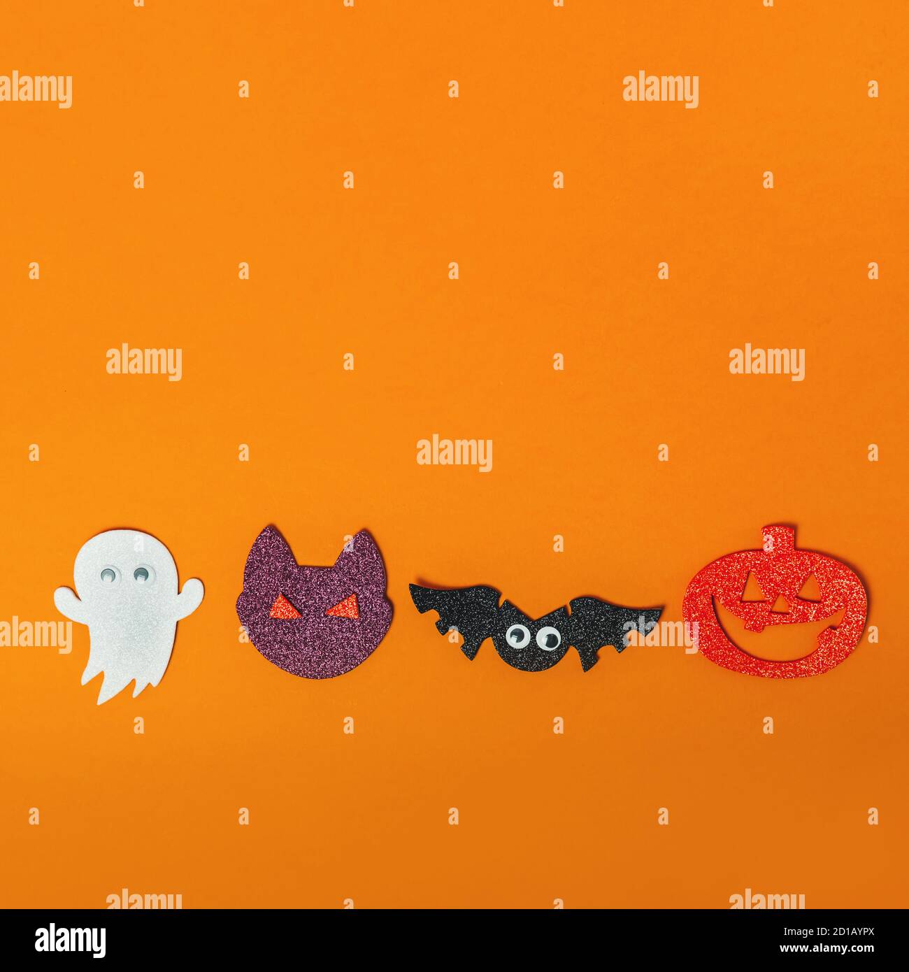 Draufsicht Halloween leuchtende Symbole, Katze, oranger Kürbis oder Jack o Laterne, weißer Geist und Fledermausschaumausschnitte auf dem orangefarbenen hellen Hintergrund. Quadrat c Stockfoto