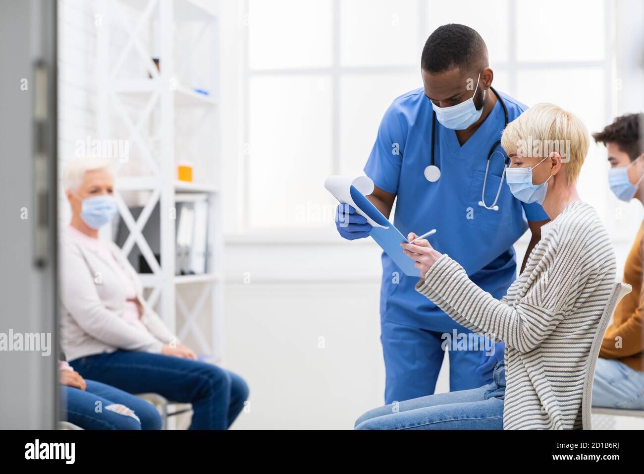 Patienten Unterzeichnung Papiere Mit Arzt Vor Coronavirus-Impfung Im Krankenhaus Stockfoto