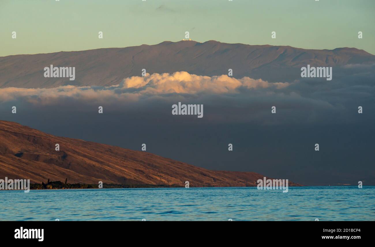 Maui, Hawaii. Blick vom Pazifischen Ozean auf den Haleakala Krater und die West Maui Berge mit Wolken. Stockfoto