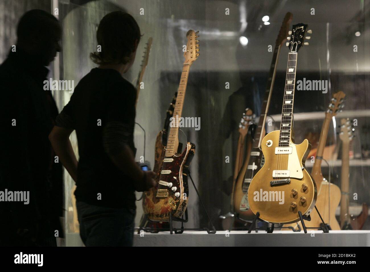 Besucher bewundern 1955 Gibson Les Paul Goldtop Gitarre, David Gilmour von  Pink Floyd (R) und eine Sunburst Fender Stratocaster, die früher im Besitz  von Jimi Hendrix (L) auf der "Reisen Gitarren" Messe