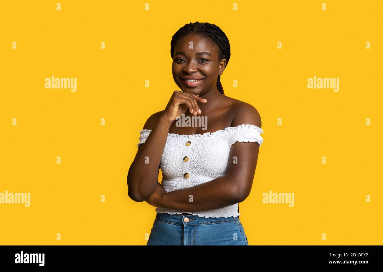 Porträt Der Attraktiven Millennial Black Lady Lächelt An Der Kamera, Berühren Chin Stockfoto
