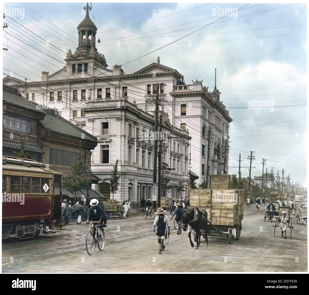 Kolorierte Ansicht einer Straßenszene mit verschiedenen Verkehrsmitteln vor dem Mitsukoshi Kaufhaus (mit Turm) in Nihonbashi, einem Geschäftsviertel in Chuo, Tokio, Japan, 1922. (Foto von Burton Holmes) Stockfoto