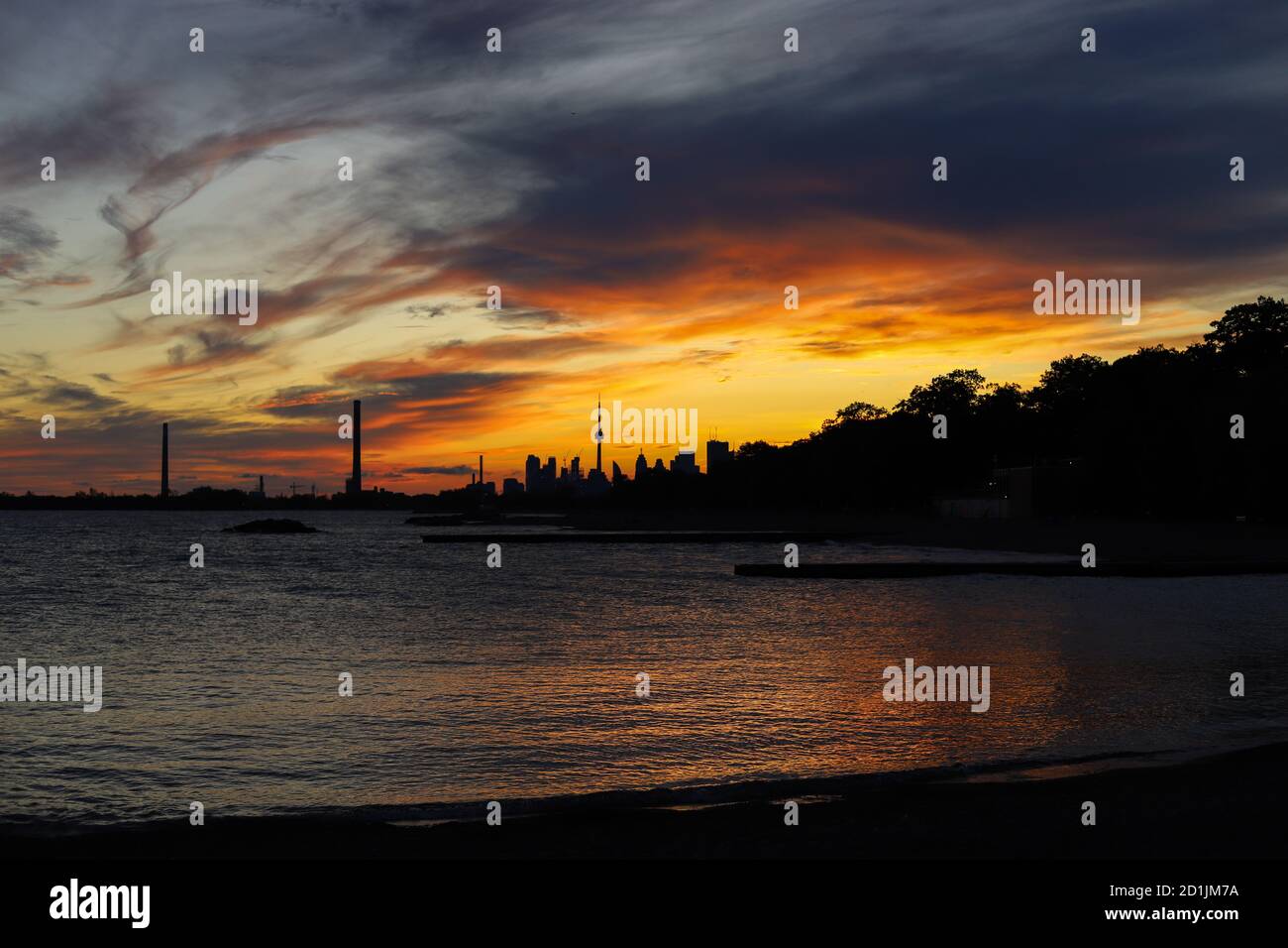 Sonnenuntergang in der Stadt. Dunkelheit Stadtbild und goldene Stunde. Blaue und gelbe Farben bewölkten Himmel und See Stockfoto