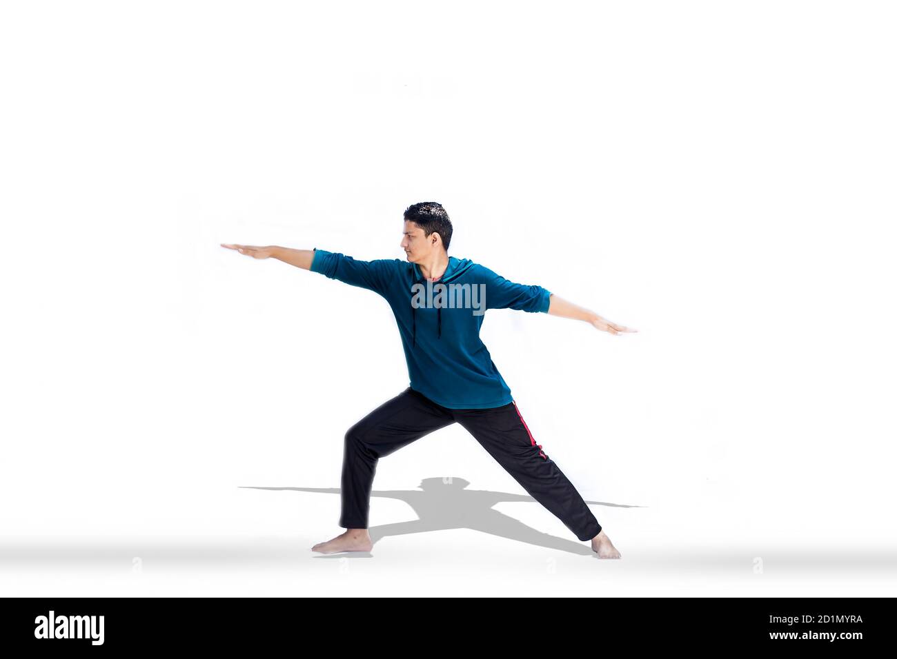 Ein junger, enthusiastischer Teenager in Sportswear, isoliert mit Reflektion und Yoga Stretch. Stockfoto