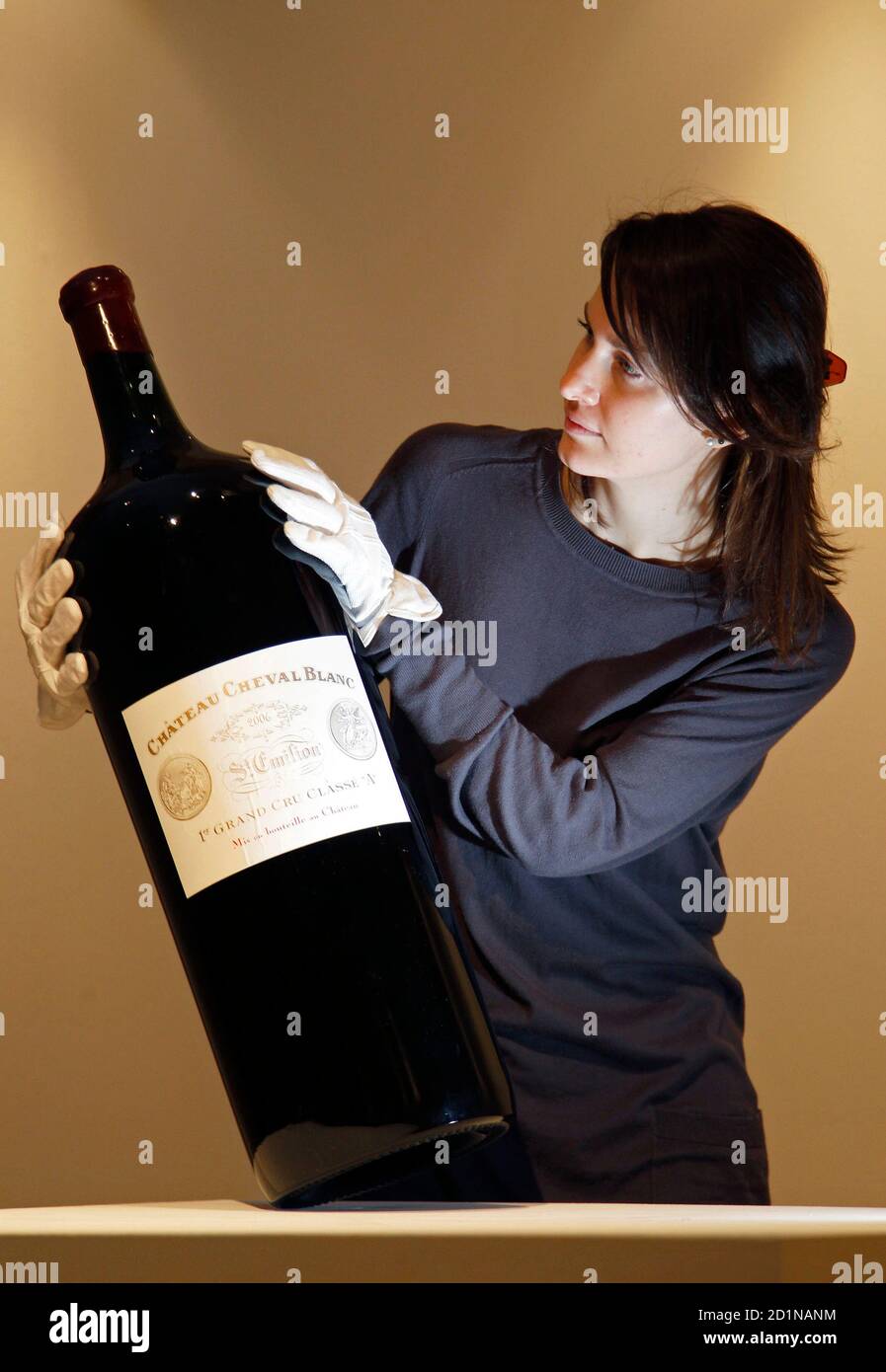 Ein Mitarbeiter stellt mit einem 18 Liter / 25kg Melchior von Château  Cheval Blanc, St. Emilion, 1er Grand Cru Classé (A), 2006 bei Sothebys  Auktionshaus in London 12. Februar 2010. Die seltene,