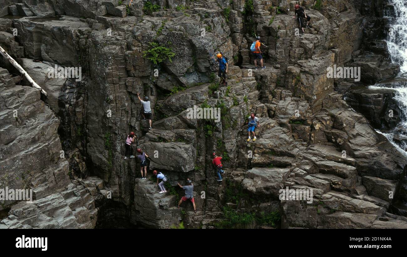 Kletterer auf der Klippe in der Nähe des Wasserfalls. Stockfoto