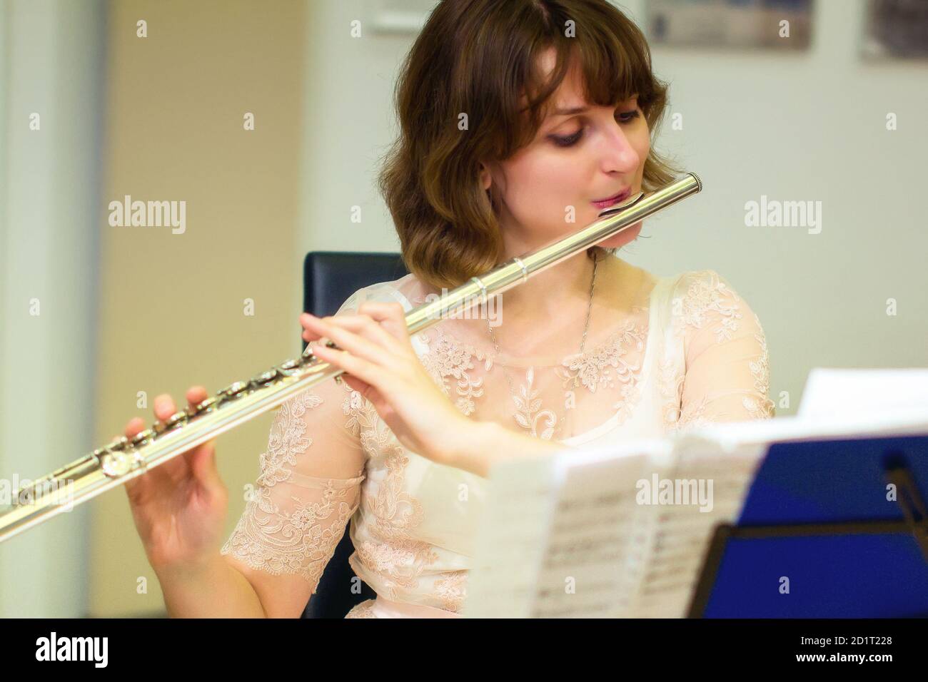 Das Mädchen spielt eine große silberne Querflöte. Eine Frau in weißen  Kleidern bläst bei einem Konzert eine Orchesterflöte. In den Händen des  Musikers Metal mus Stockfotografie - Alamy