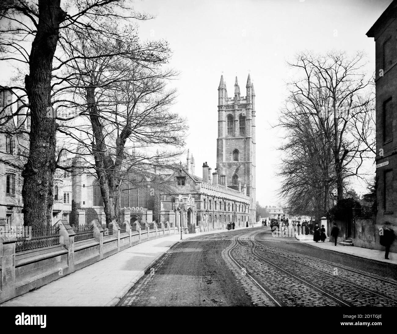 MAGDALEN COLLEGE, Oxford, Oxfordshire. Ein Blick auf die Straße entlang der High Street in Richtung des 144 Fuß hohen Glockenturms des Magdalen College. Von diesem Turm aus singt der Chor des Kollegs am 1. Mai in einer Zeremonie, die Jahrhunderte zurückreicht. Fotografiert von Henry Taunt im Jahr 1885. Stockfoto