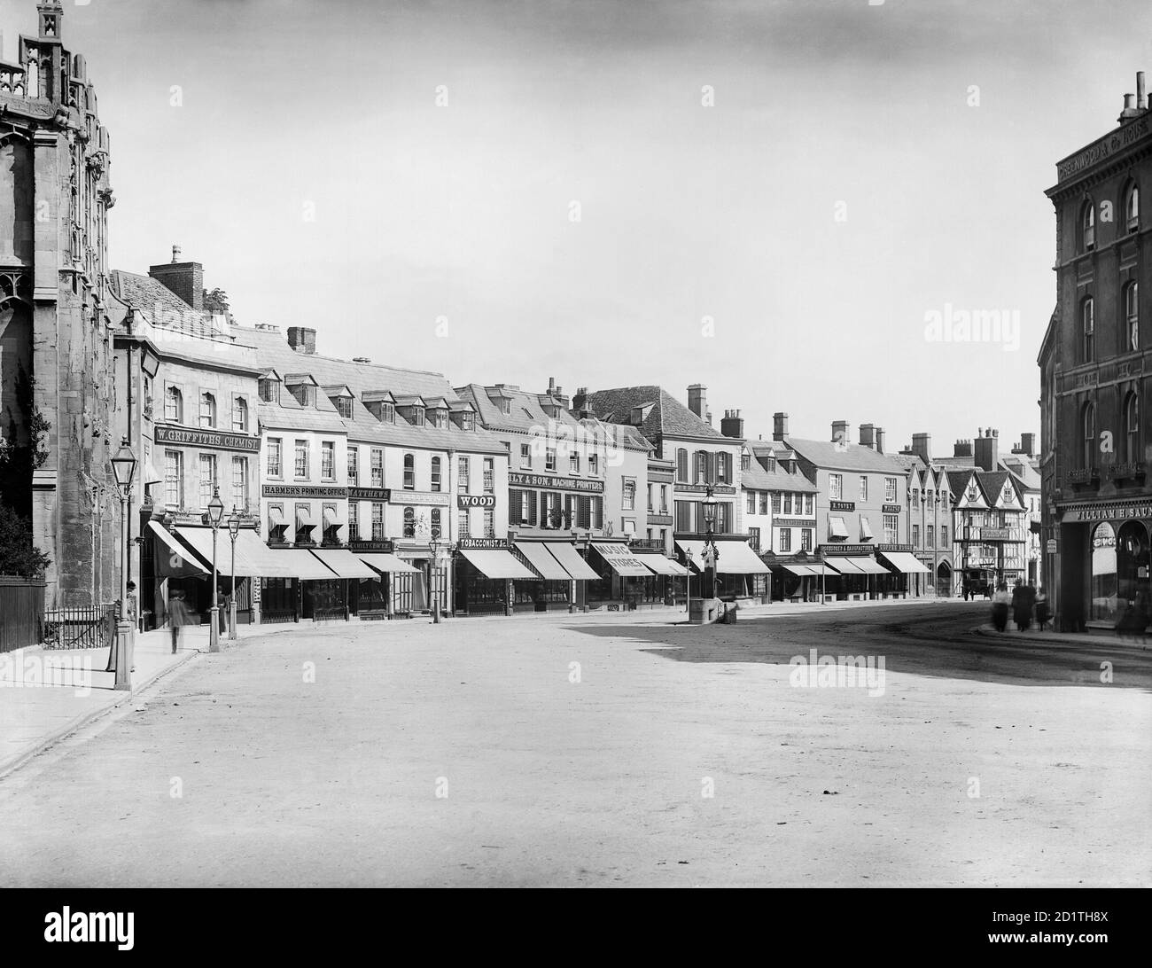 CIRENCESTER, Gloucestershire. Blick auf den Marktplatz von der Pfarrkirche der Hauptstadt der Cotswolds. Zeigt die Ladenfronten auf der Nordseite mit ihren Markisen über dem Bürgersteig. Fotografiert 1883 von Henry Taunt. Stockfoto