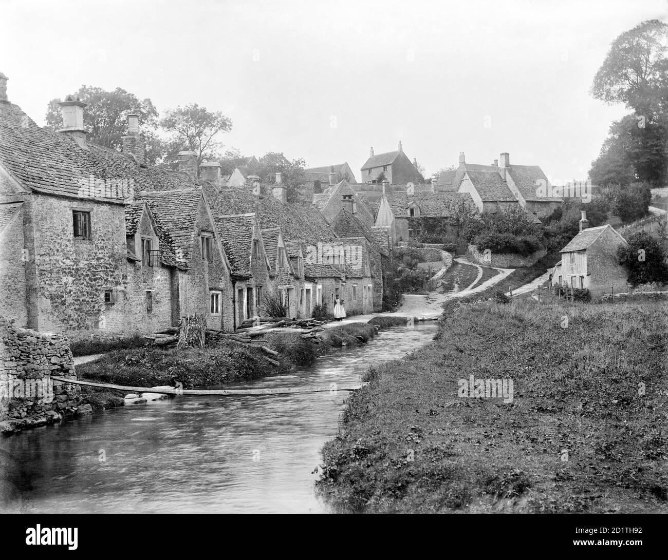 ARLINGTON ROW, Bibury, Gloucestershire. Blick auf die bekannte Reihe von Cotswold Steinhütten am Fluss Coln. Diese wurden im frühen 17. Jahrhundert in Wohnungen aus einem klösterlichen Schafhaus aus der zeit um 1380 mit zehn Buchten von Kruckbinen umgewandelt. Fotografiert 1901 von Henry Taunt. Stockfoto