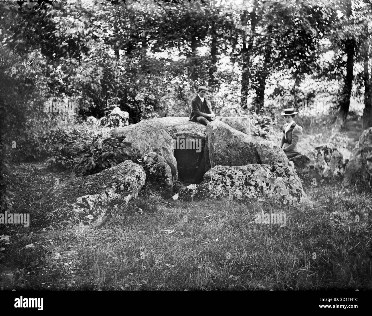 WAYLANDS SCHMIEDE, Ashbury, Oxfordshire. Der neolithische Kammkarren, vom Westen genommen, mit einer Dame und einem Herrn, der auf den Steinen beim Eingang saß. Dies zeigt den Standort weit vor seiner Restaurierung nach Ausgrabungen in den 1960er Jahren. Fotografiert von Henry Taunt (aktiv 1860 - 1922). Stockfoto