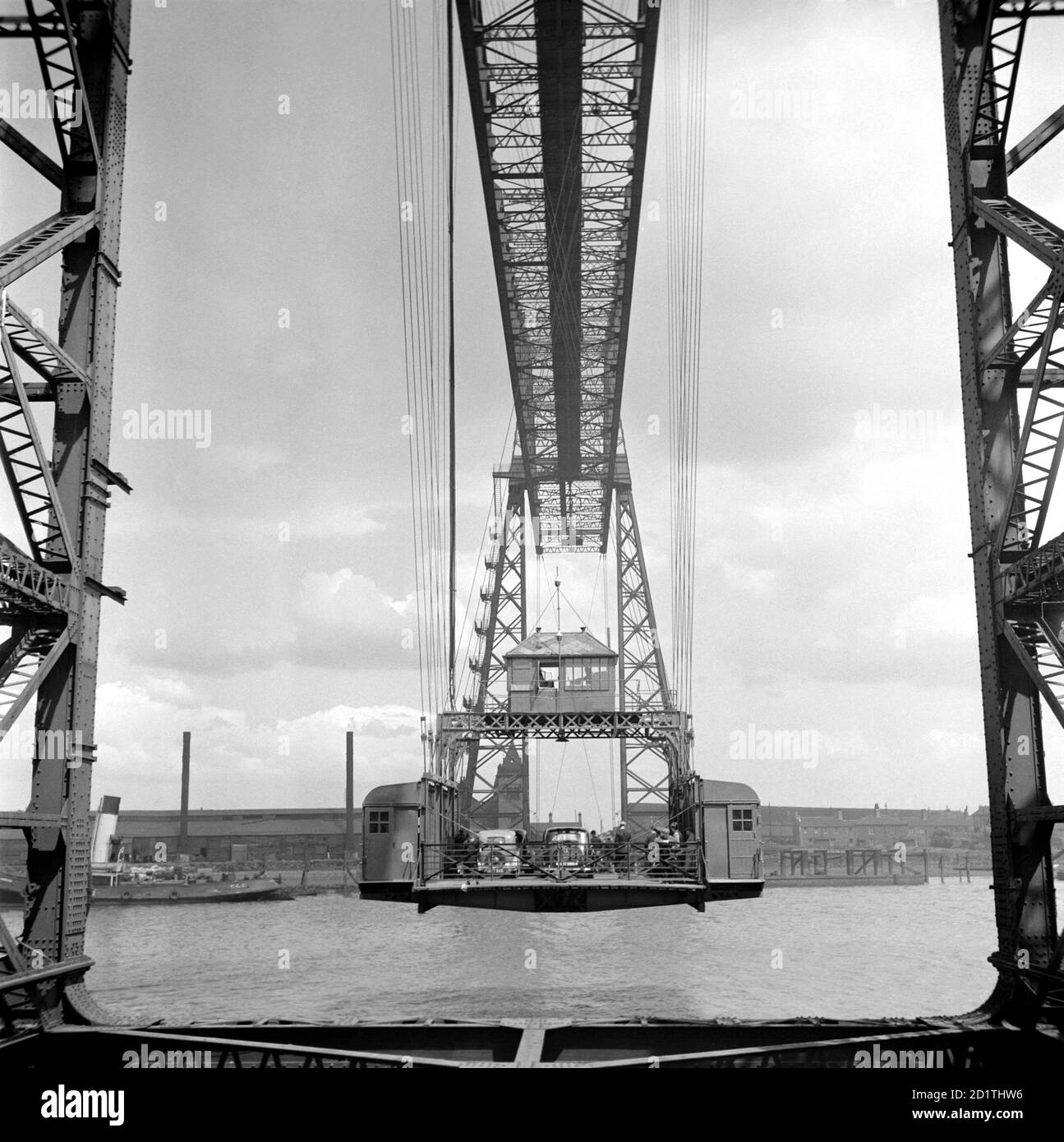 TRANSPORTER BRIDGE, Middlesbrough, Cleveland. Diese Transporterbrücke ist eine von nur vier in Großbritannien. 1911 erbaut, wurde eine bewegliche Plattform von Kabeln aus einem Stahlrahmen abgeschleppt und Passagiere und Fahrzeuge über den Fluss Tees transportiert. Dieses Design wurde gewählt, um die Unterbrechung des Versandbetriebs zu minimieren. Fotografiert von Eric de Mare im Jahr 1955. Stockfoto