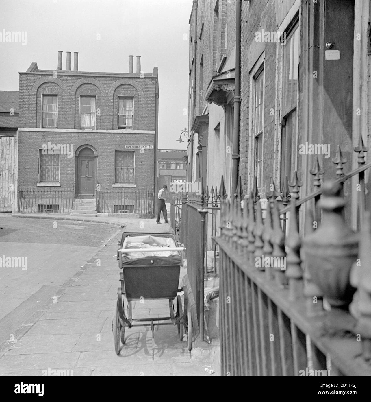 SWEDENBORG SQUARE, Stepney, London. Ein Kinderwagen steht auf dem Bürgersteig vor einem Haus auf dem Swedenborg-Platz. An der Ecke steht ein freistehendes Haus. Fotografiert von Eric de Mare. Datumsbereich: 1945-1960. Stockfoto