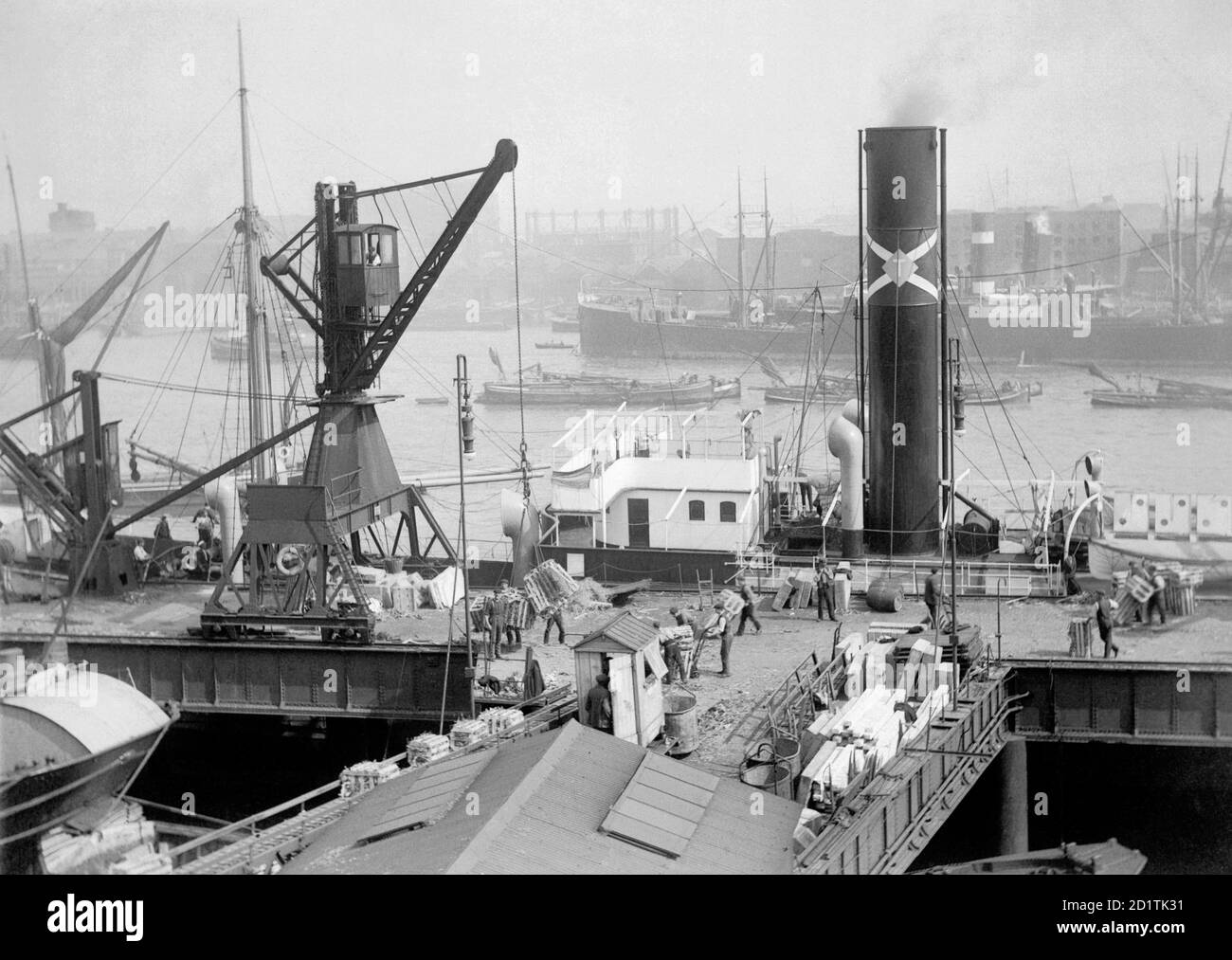 BUTLER'S WHARF, Shader Thames, London. In London werden zum Schutz in Stroh verpackte Warenkisten entladen und auf dem Förderband zu den Lagerhäusern aufgestellt. Die kleine Hütte in der Mitte des Bildes ist wahrscheinlich, wo der Aufseher Aufzeichnungen über die Ladung gehalten. Aus der Sammlung Butlers Wharf: Einige Zeit vor 1910 gaben die Direktoren von Butlers Wharf Ltd eine Serie von Fotografien in Auftrag, die Aspekte der Arbeit des Unternehmens detailliert aufzeigen. Stockfoto