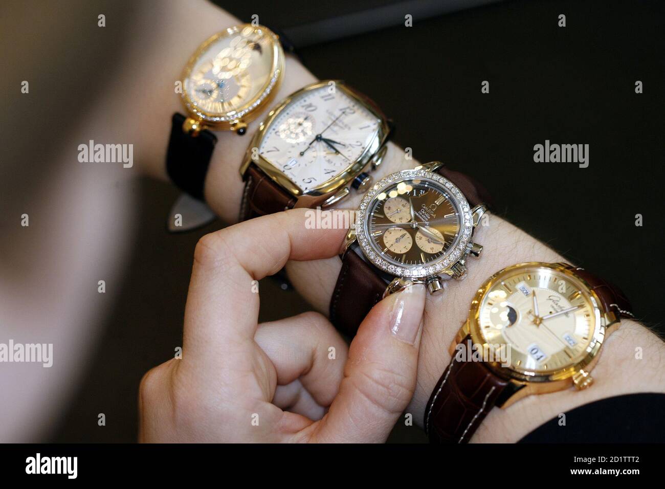 Eine Verkäuferin zeigt von Marken zu Schweizer Swatch Group (L-R) Breguet,  Longines, Omega und Firmenkomplex in einem Uhren- und Schmuck-Shop in  Zürich gehören, in dieser 22. März 2006-Datei Foto. Gefälschte Uhren sind