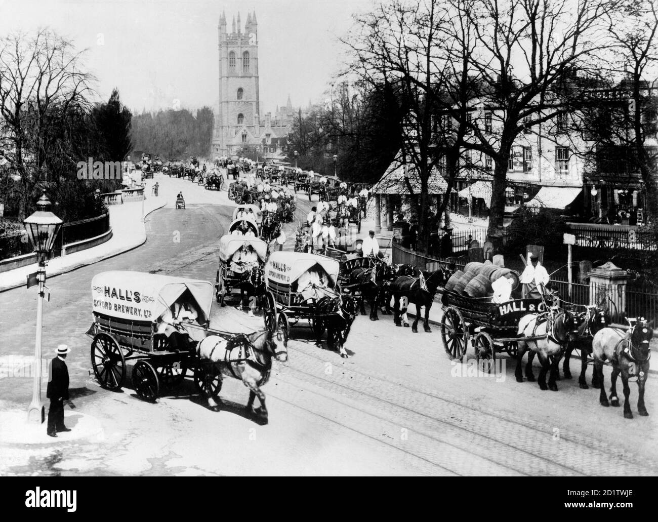 MAGDALEN BRIDGE, Oxford, Oxfordshire. Die Hall's Brewery liegt 1912 vor den Oxford May Day Prozessionen. Die Prozession hat gerade die Magdalenbrücke passiert und der Turm aus dem 15. Jahrhundert ist im Hintergrund zu sehen. Fotografiert von Henry Taunt im Mai 1912. Stockfoto