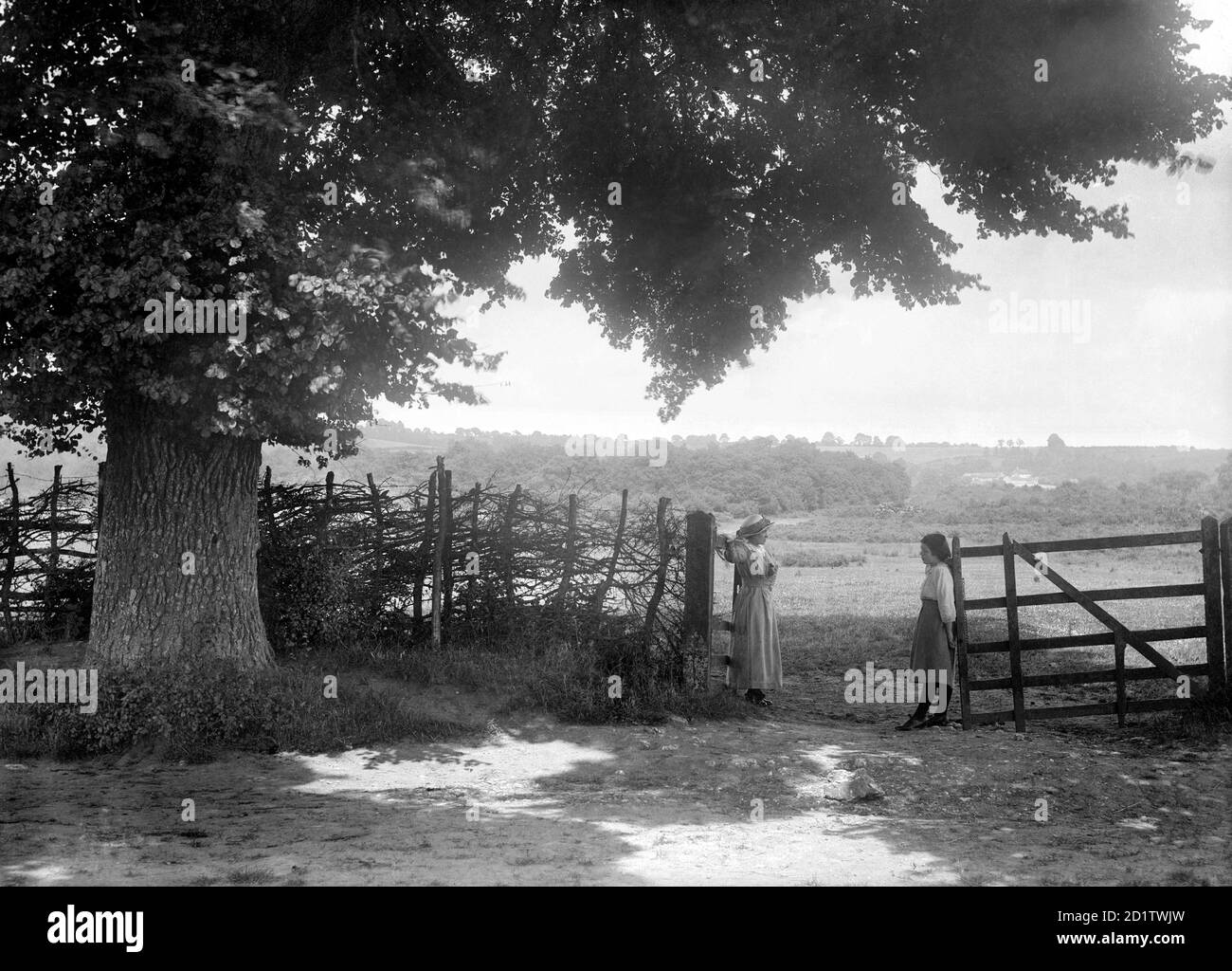 ÖFFNEN SIE BRASENOSE, Horspath, South Oxfordshire. Ein malerischer Blick auf die Landschaft von Oxfordshire mit zwei Frauen, die an einem Tor stehen. Fotografiert von Henry Taunt im Juli 1916. Stockfoto
