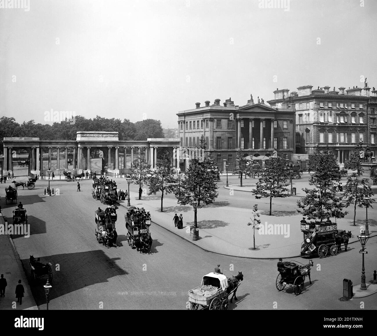 HYDE PARK ECKE, Westminster, London. Blick nach Norden in Richtung Hyde Park Corner Screen (von Decimus Burton) und Apsley House (heute Wellington Museum). Apsley House wird als das letzte in einer Reihe von Gebäuden auf Piccadilly gezeigt - seine Nachbarn sind nun verschwunden. Der gesamte Verkehr ist von Pferden gezogen und umfasst Busse und Wagen. Fotografiert um 1900 und Carl Norman zugeschrieben. Stockfoto