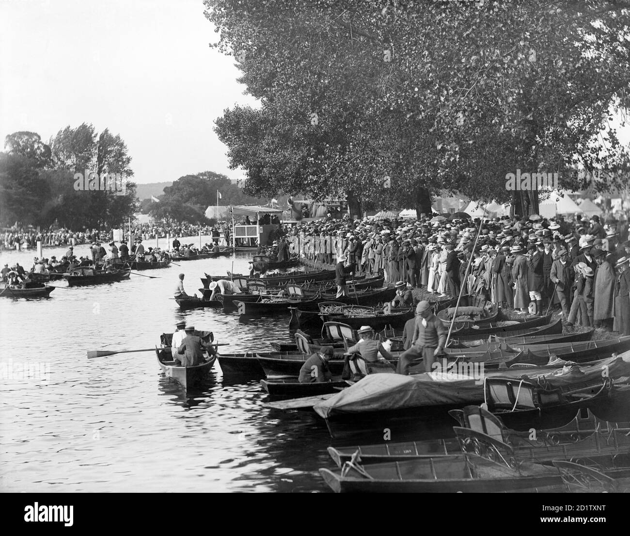 HENLEY-ON-THAMES, OXFORDSHIRE. Massen von Zuschauern am Ufer des Flusses und Boote, die in der Nähe während der Regatta, einem wichtigen sozialen und wettbewerbsorientierten Ereignis, das jedes Jahr auf der Themse seit 1839 stattfindet, festgemacht wurden. Fotografiert von Hentry Taunt im Jahr 1902. Stockfoto