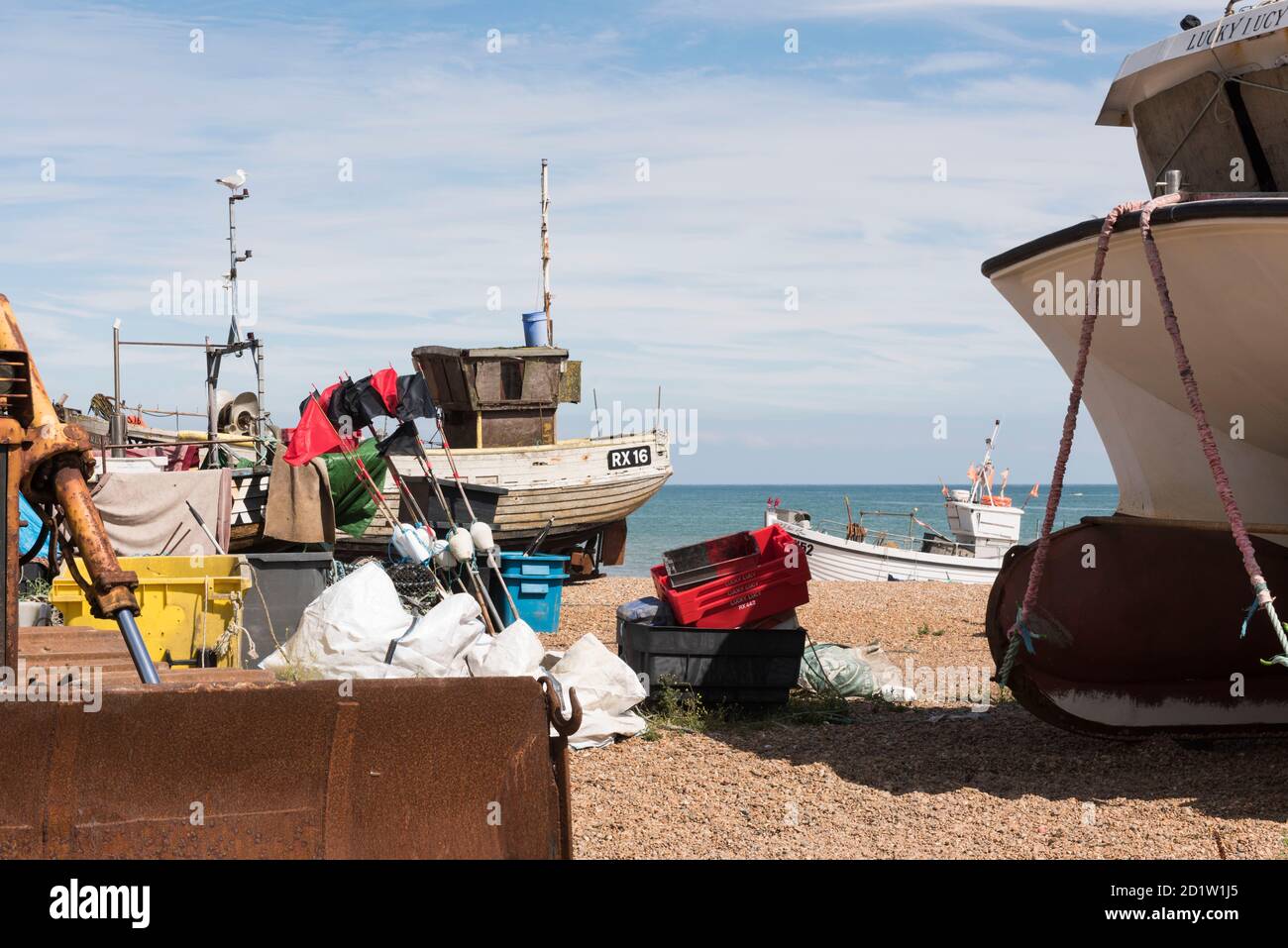 Gesamtansicht des Stade Strandes von Norden, zeigt Fischerboote und zugehörige Angelausrüstung auf dem Kiesel, The Stade, Hastings, East Sussex, UK. Stockfoto