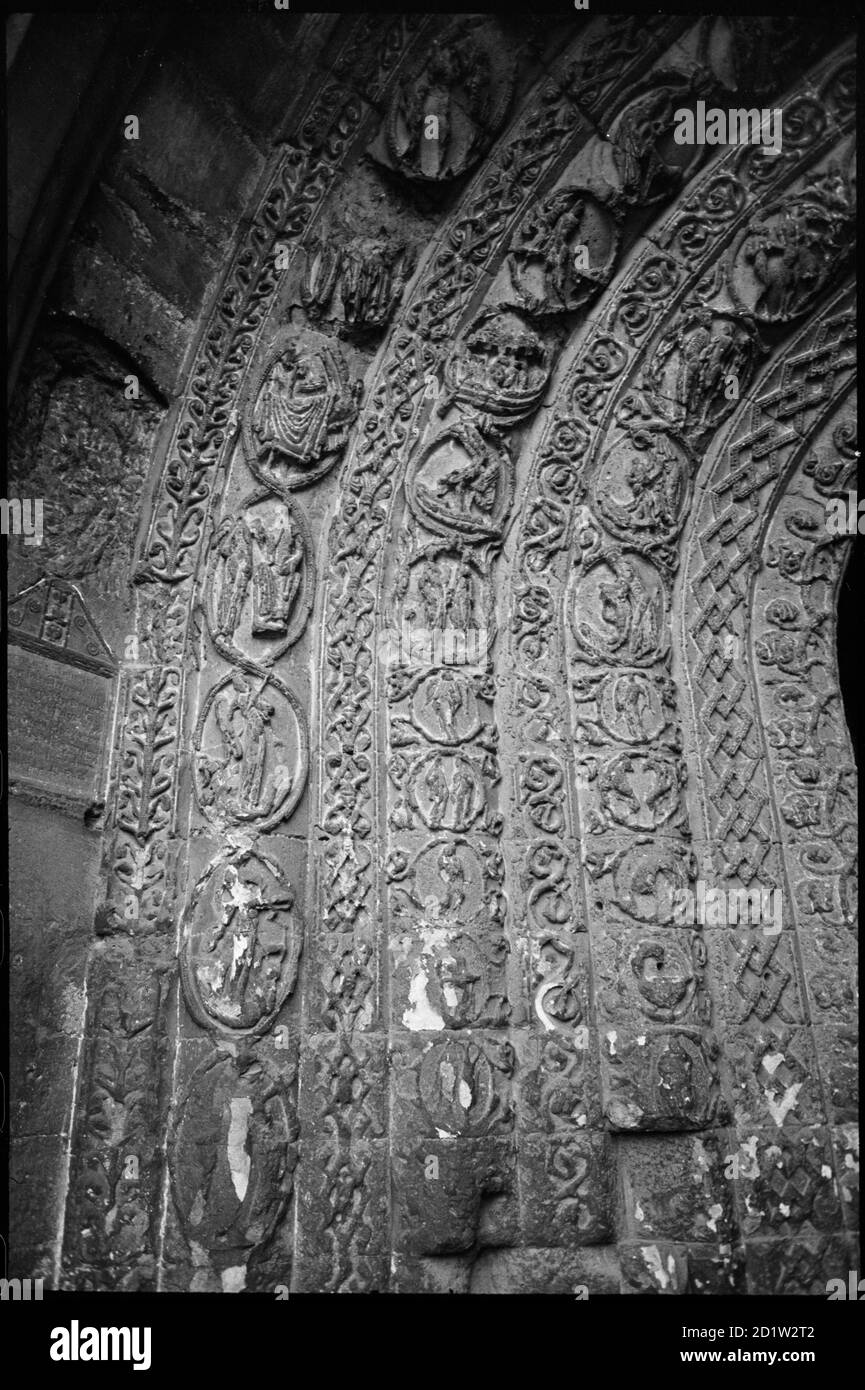 Nahaufnahme des äußeren Eingangs der Südveranda, zeigt die geschnitzten inneren Bögen, die stark mit biblischen Szenen in runden Rändern verziert sind, abwechselnd mit Bändern aus geschnitzten Mustern, Malmesbury, Wiltshire, Großbritannien. Stockfoto