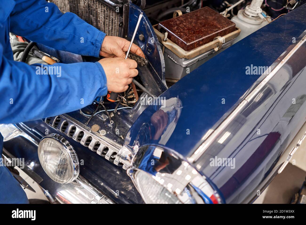 Retro-Auto, Amateur Sammler repariert sein Auto. Mechaniker Hände Überprüfung der Gebrauchstauglichkeit des Autos in der offenen Haube, Nahaufnahme. Reparaturen elektrisch Stockfoto