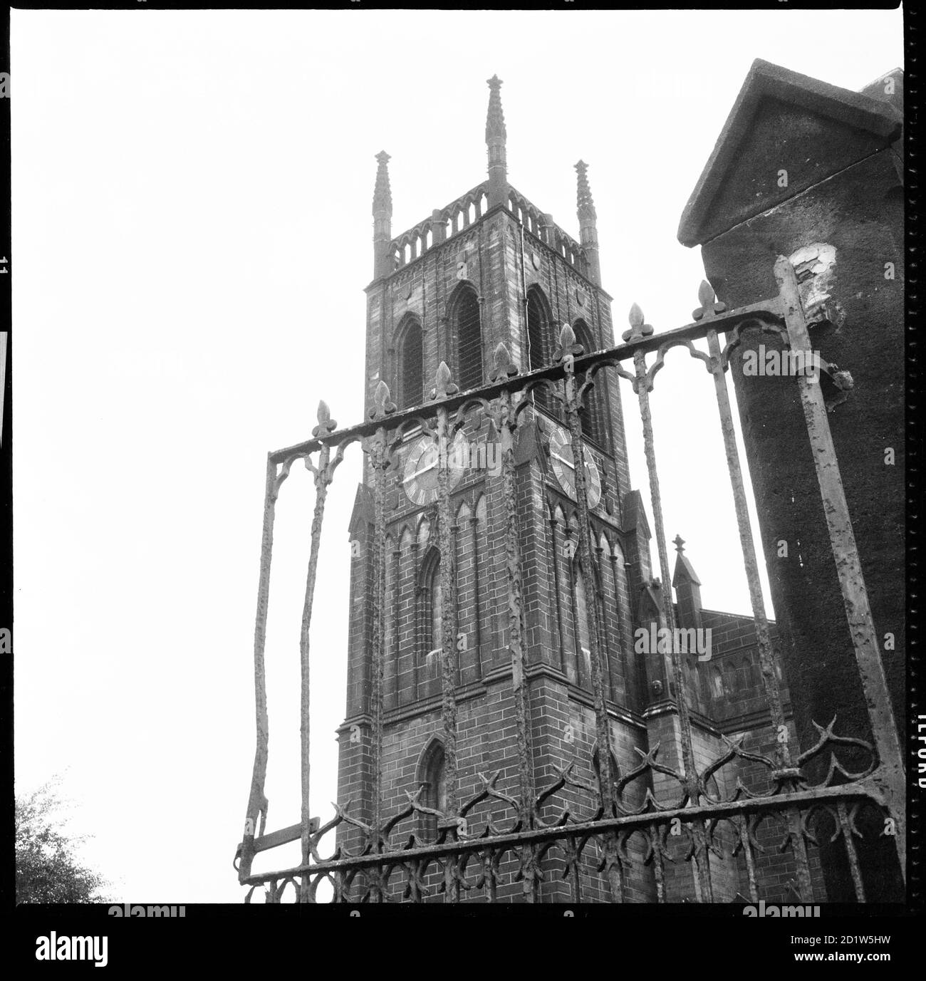 Der Turm der St Mary's Church, von der aus man durch das schmiedeeiserne Kirchtor, St Mary's Street, Quarry Hill, Leeds, UK, sieht. Stockfoto