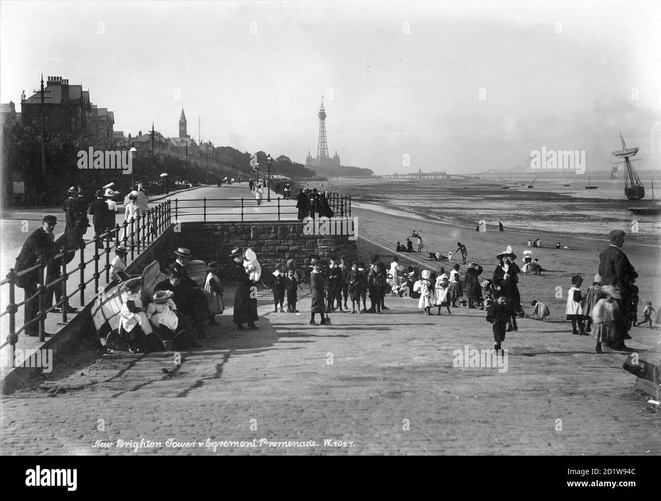 Menge auf der Egremont Promenade mit New Brighton Tower im Hintergrund. Stockfoto