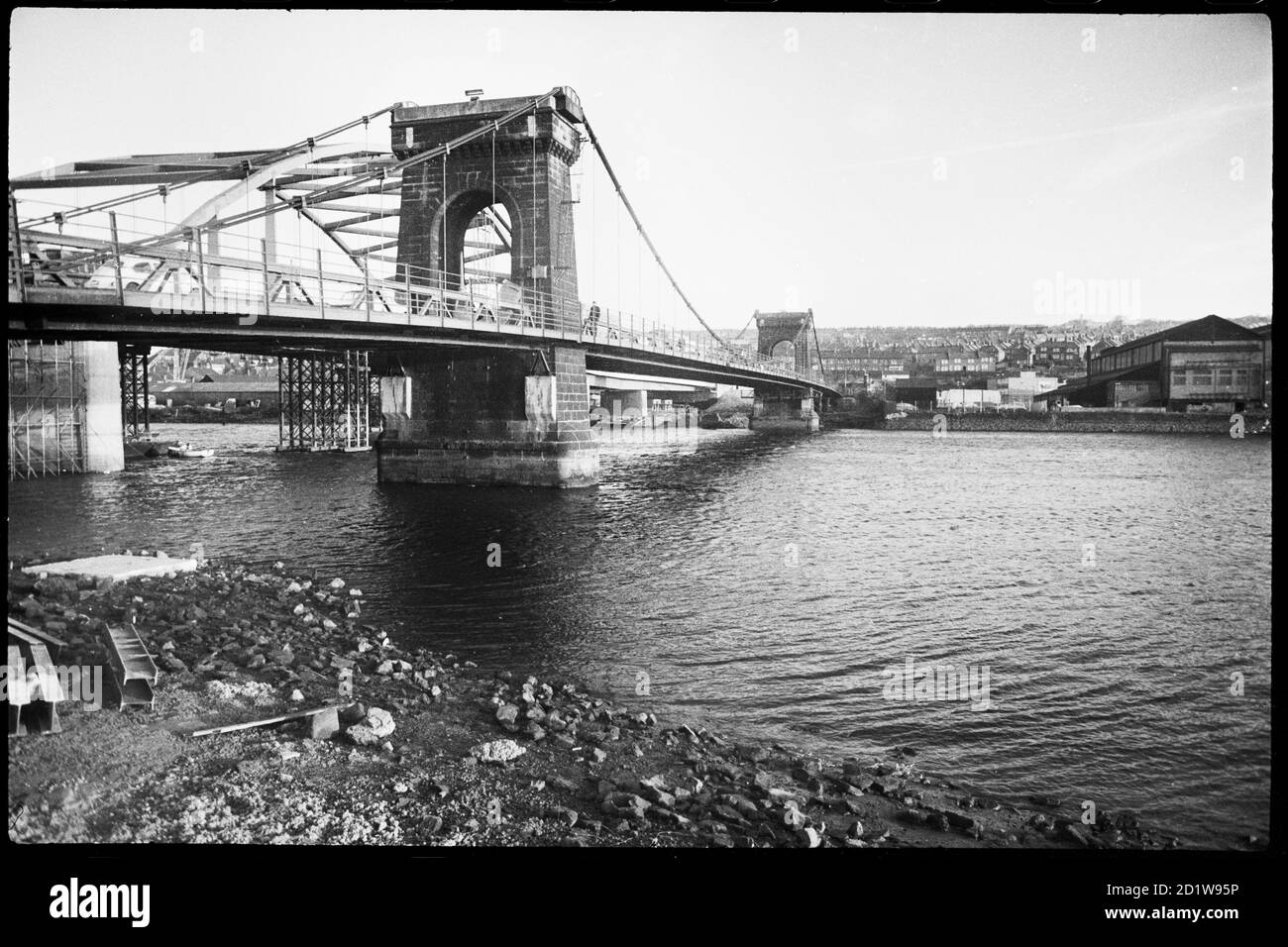 Allgemeine Ansicht der Old Scotswood Bridge, lokal als Kettenbrücke bekannt, eine Hängebrücke mit zwei großen steinernen Flusspiers, eröffnet im April 1831 und abgerissen im Jahr 1967, und zeigt den Bau der neuen Scotswood Bridge im Hintergrund. Stockfoto