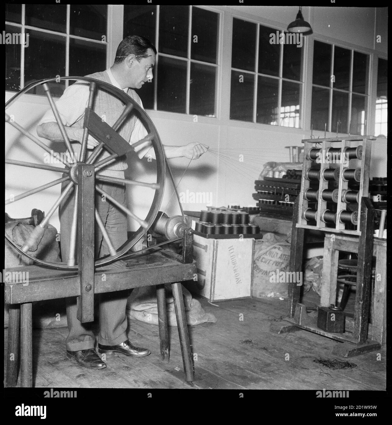 Ein Mann mit einem handbetriebenen Seidendoppelrad bei Wellington Silk Mills. Stockfoto