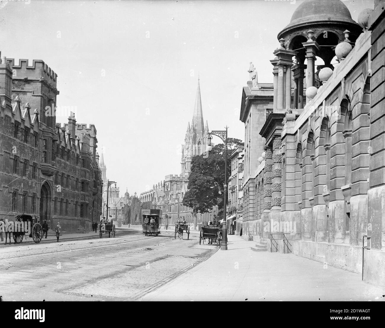 High Street, Oxford, Oxfordshire. Allgemeine Ansicht nach Westen entlang der High Street mit dem Eingang zum Queens College im Vordergrund und St. Mary's Kirche dahinter. Stockfoto