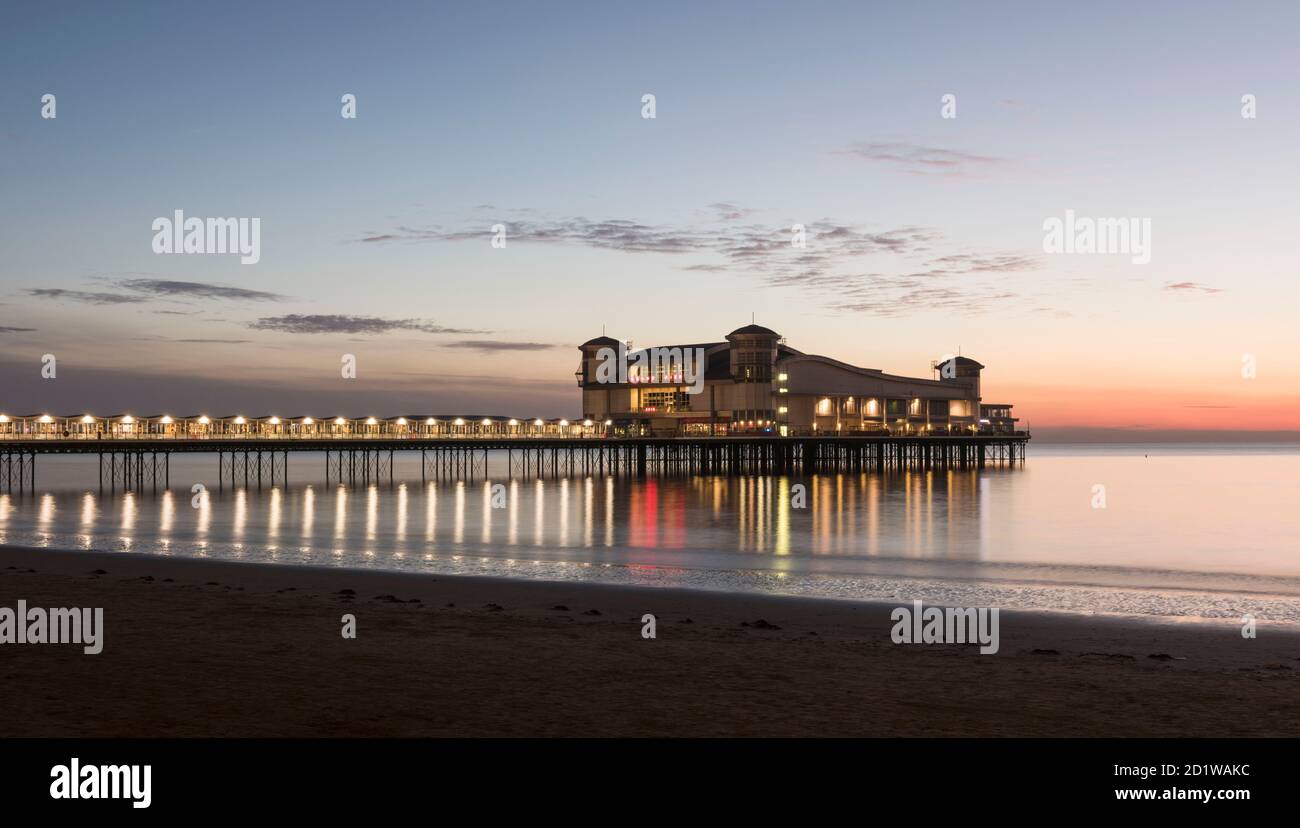 Grand Pier, Marine Parade, Weston-Super-Mare, North Somerset. Allgemeine Ansicht des Piers, beleuchtet in der Dämmerung, von Nord-Osten, bei Ebbe. Stockfoto