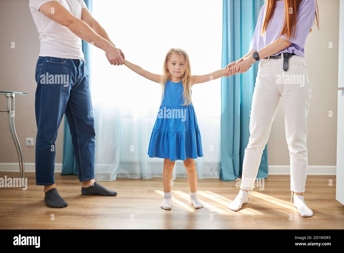 Kleine Tochter Mädchen will nicht, dass die Eltern geschieden werden, trauriges Mädchen hören Streitereien der Eltern, wollen glückliche Familie Stockfoto